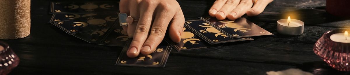 manos de taroprista deslizando cartas sobre mesa negra